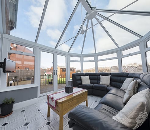 white conservatory interior with large corner sofa