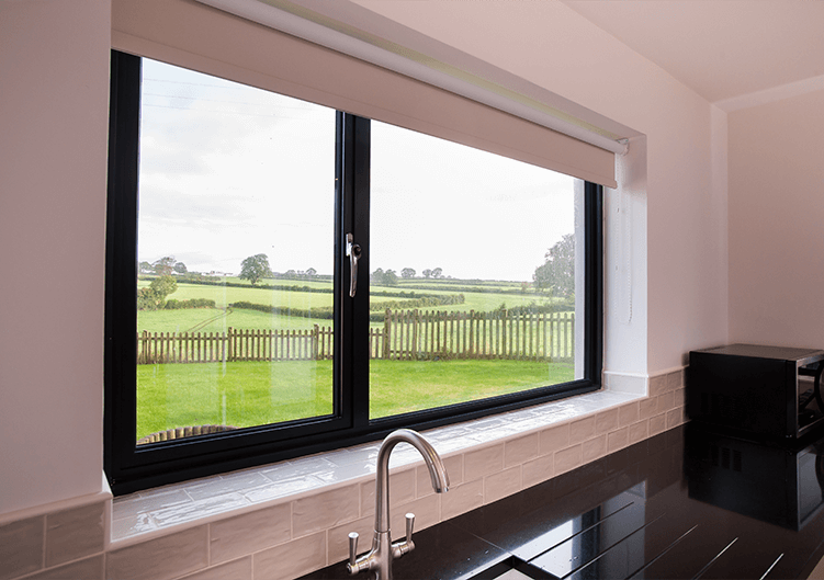 Black aluminium window over sink looking out to garden